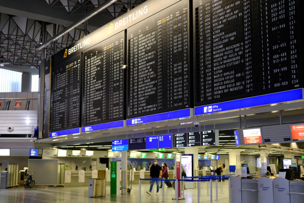 Airport arrival/departure board showing dozens of flights 