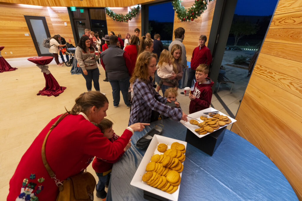 Young families gathered at holiday event where cookies are served. 