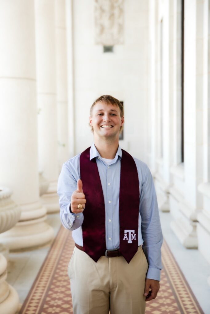 A waist up photo of Ryder Nielson wearing a Texas A&M University graduation stole. 