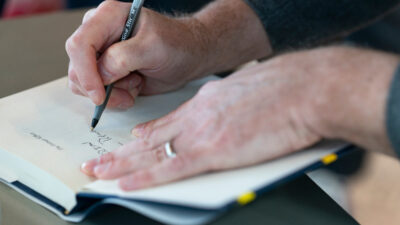 A man is writing notes in a notebook.