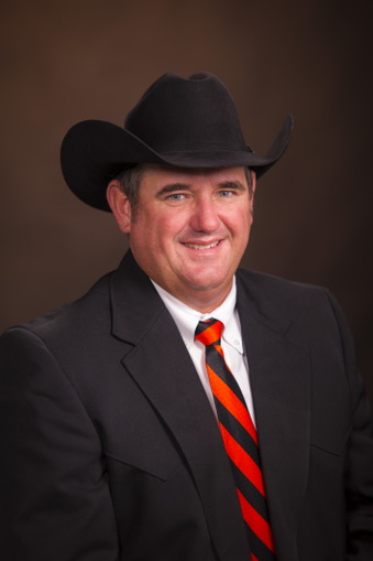 A man, Todd Baughman, in a suit and tie and wearing a black cowboy hat