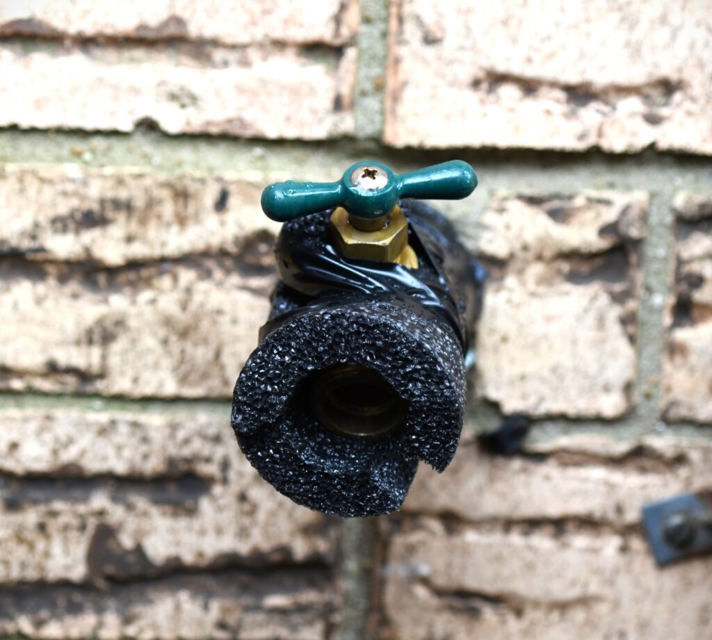 A water spigot wrapped in pipe insulation for protection against winter weather. 