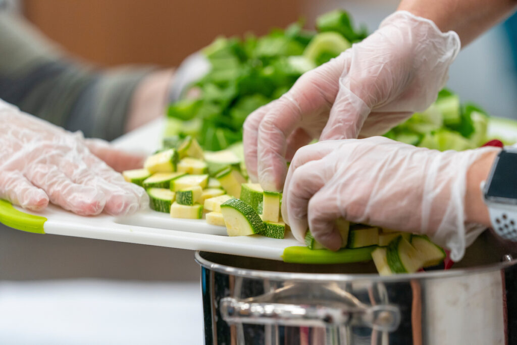 A person is preparing food in the kitchen. The "Cooking Well with Diabetes" course will teach participants how to select and prepare healthy foods to help manage diabetes.