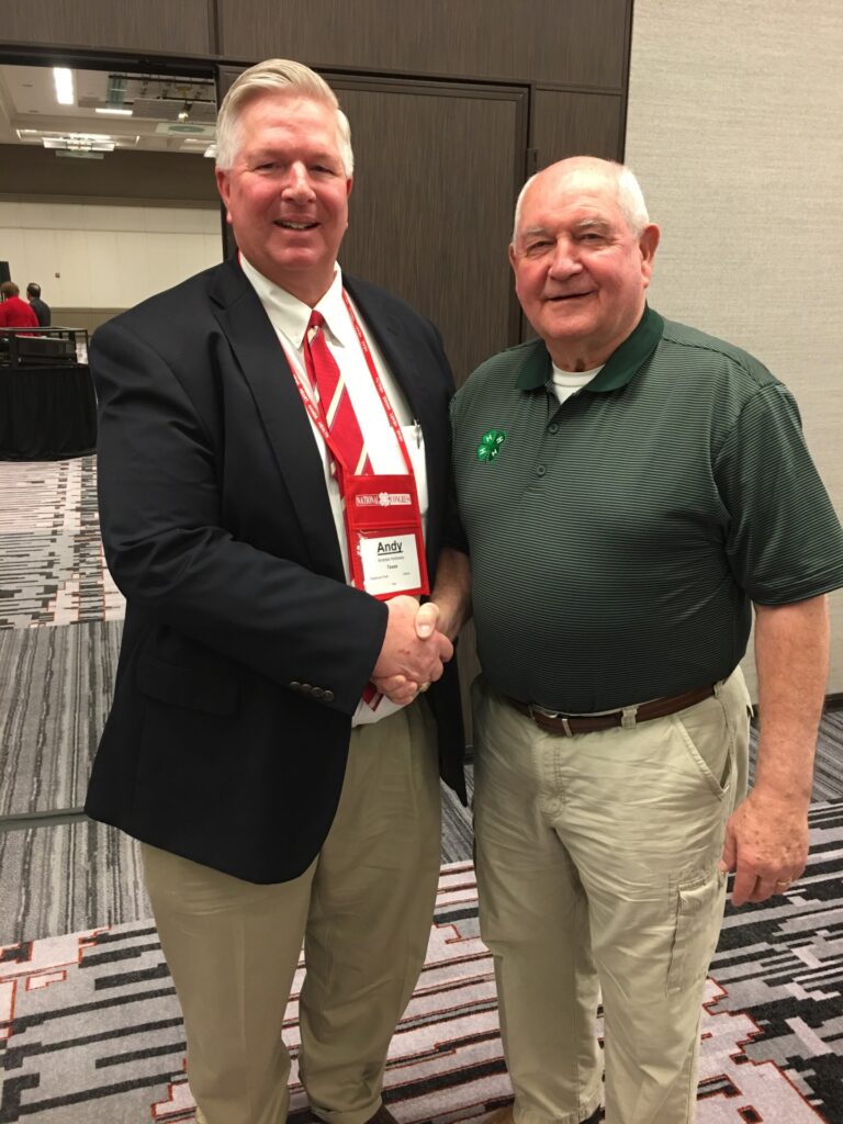 Andy Holloway shaking hands with Sonny Perdue. 