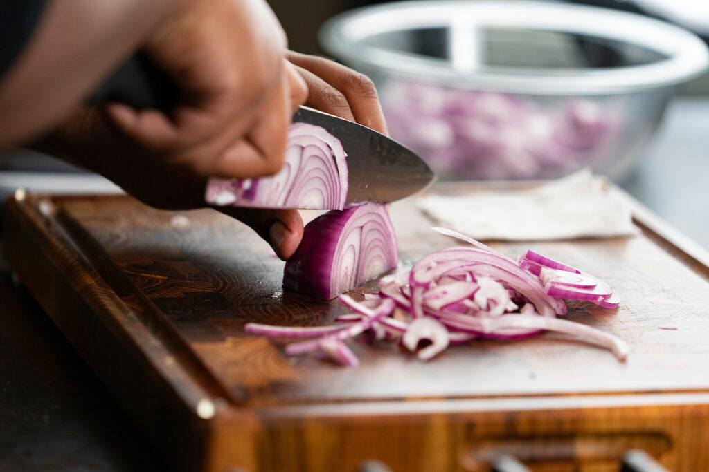 A person is cutting an onion to be cooked in a dish. he March 18 and 21 professional food manager certification course in Pampa will provide food safety training and prepare participants for the professional food manager certification exam. 