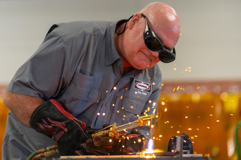A man is welding a piece of steel during a demonstration at a recent Summer Ag Academy. 