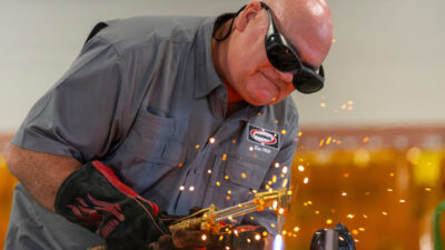 A man is welding a piece of steel during a demonstration at a recent Summer Ag Academy.
