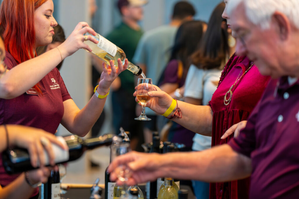 A woman pouring wine at a Spirited Learning event. 