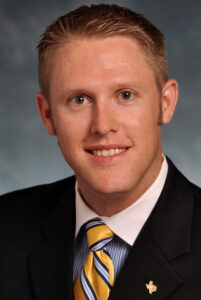 Head and shoulders photo of Kody Bessent, wearing suit and tie