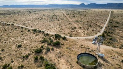 An aerial view of a West Texas ranch with a well.