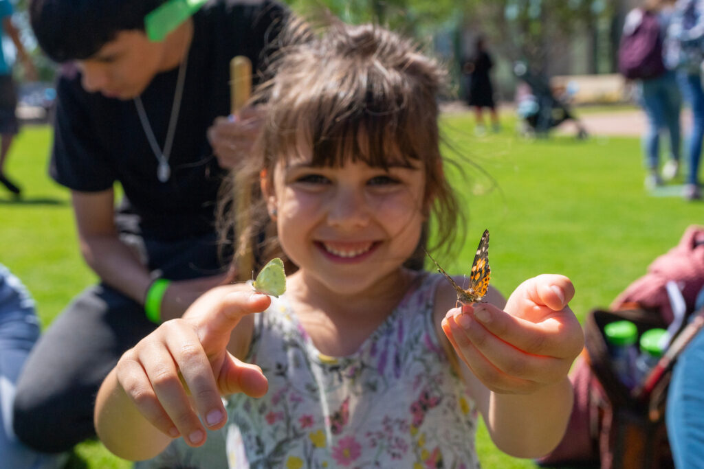 Young girl with butterflies resting on her fingertips at Hullabloom Fest, April 23, 2023.