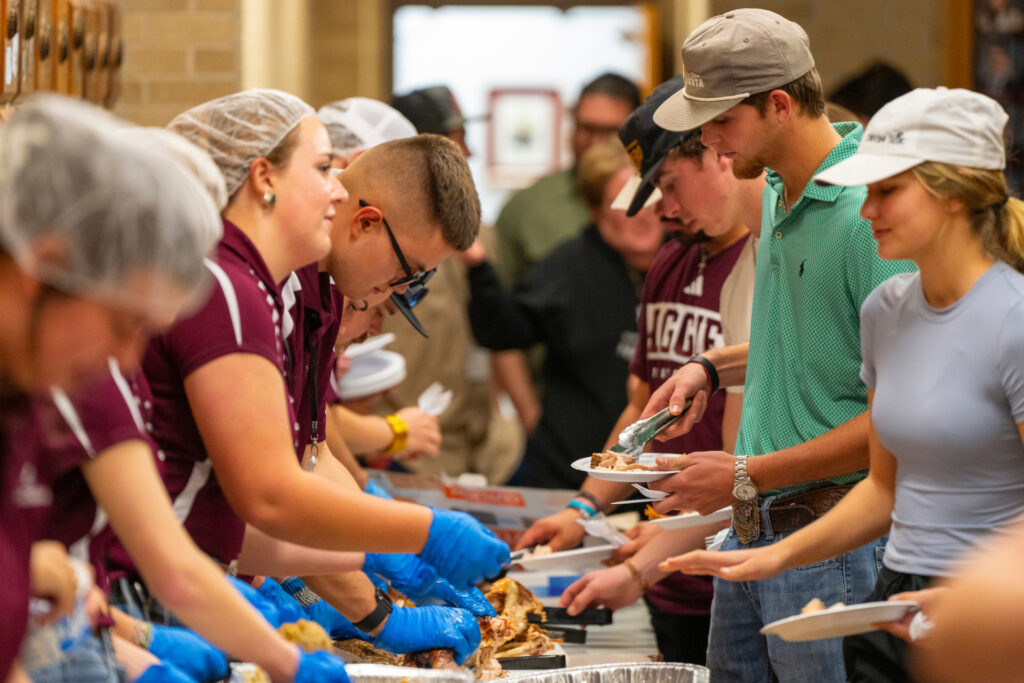People are being served food at an event. The April professional food manager certification course in Waco will provide food safety training for participants and prepare them for the professional food manager certification exam. 
