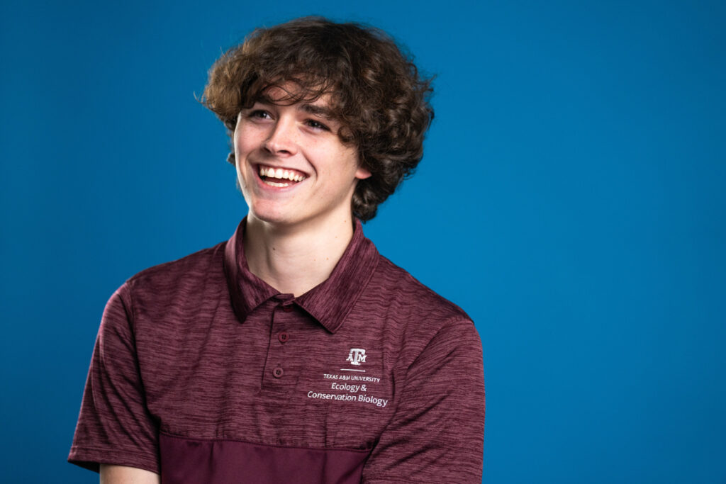 Head and shoulders of Skyler Nix. He is wearing a maroon shirt with that has a ATM with the words Texas A&M University Ecology & Conservation Biology 