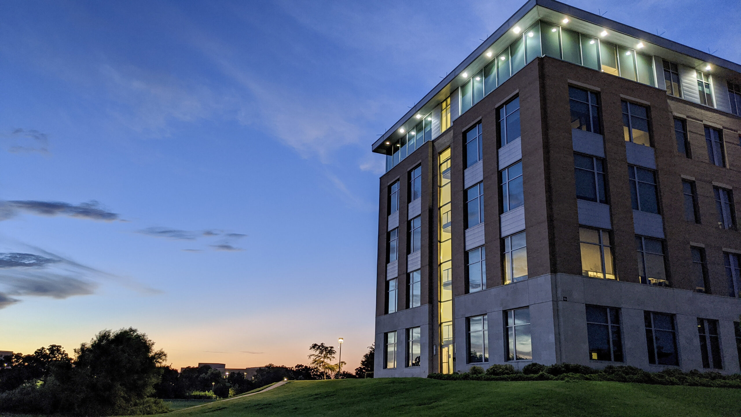 The College of Agriculture and Life Sciences building in front of a blue, orange and yellow sunset.