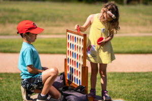 Two children are playing a game of Connect Four during a recent Summer Celebration at The Gardens at Texas A&M University.