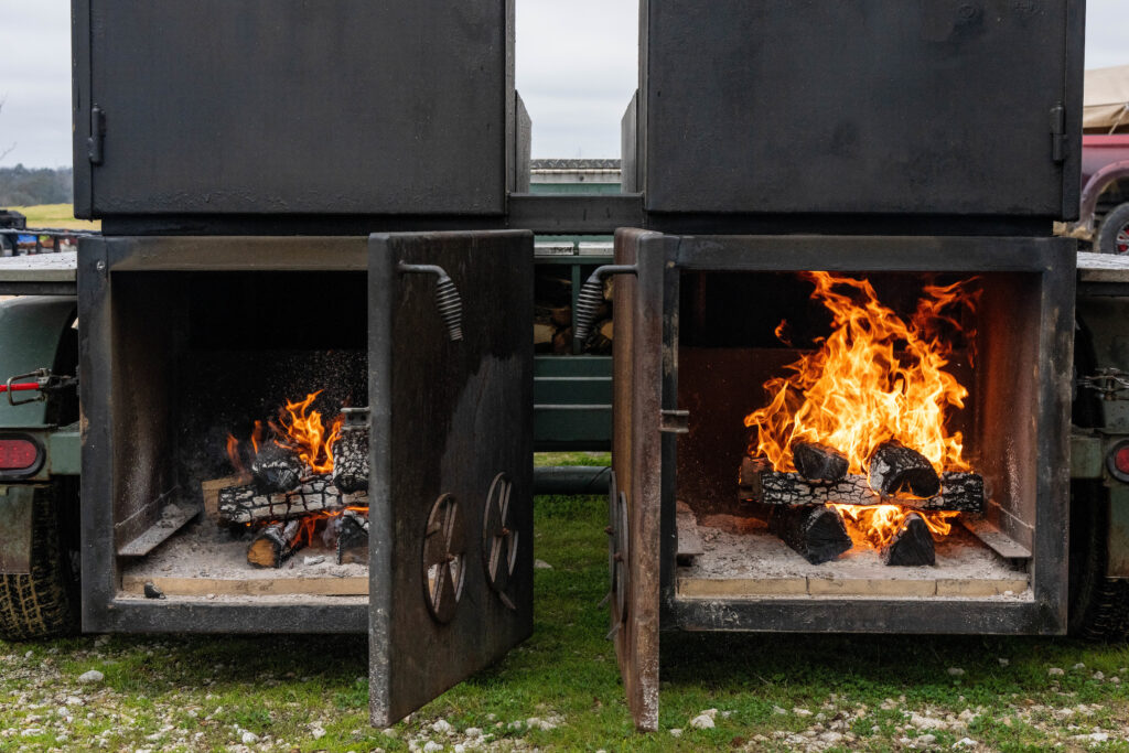 Fires burning inside two large smokers. 