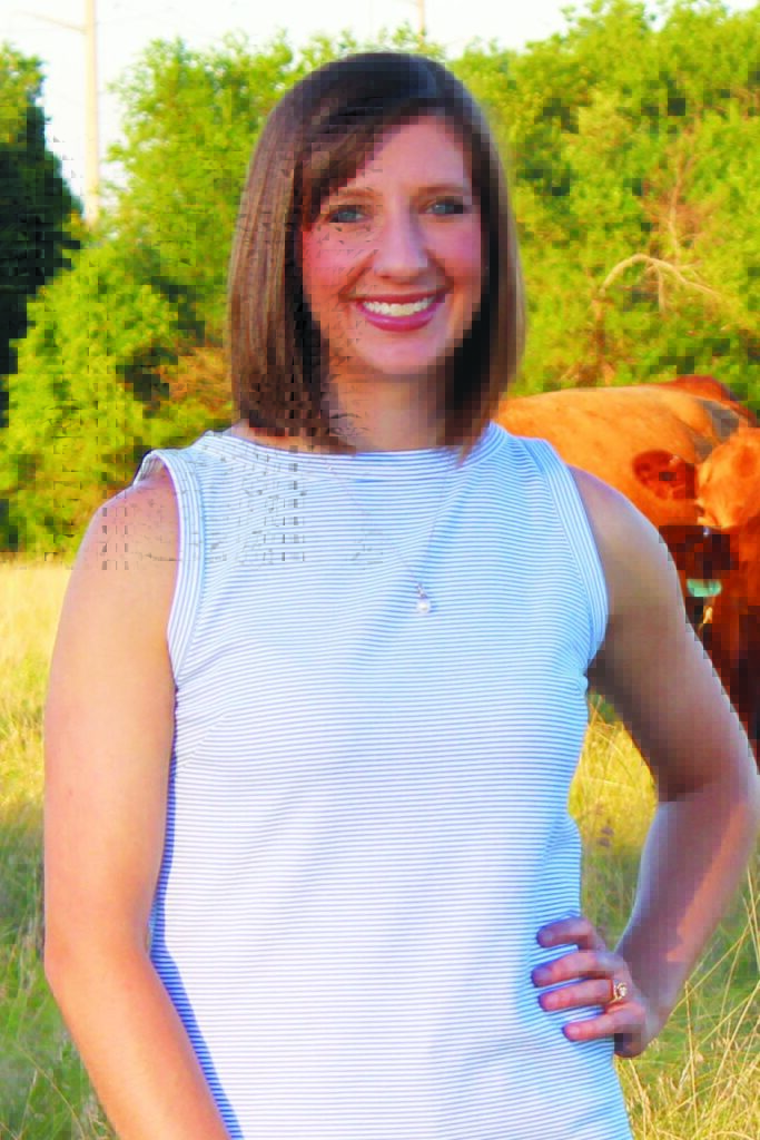 Headshot of Myriah Johnson. She is wearing a light colored stripped top and has her left hand on her hip. There are trees and cattle behind her.