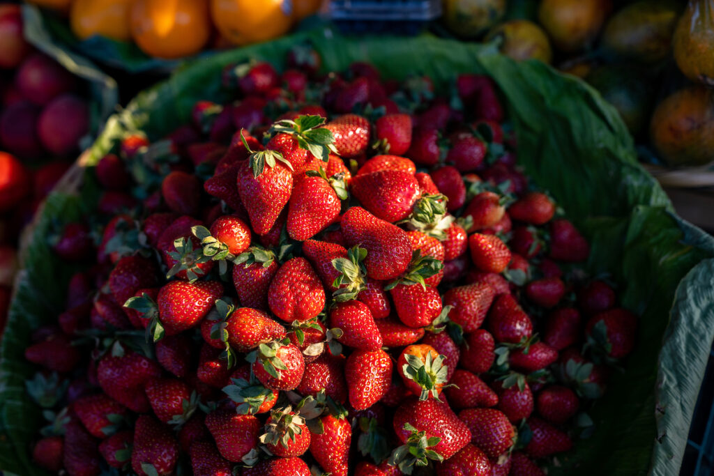 A bushel of strawberries at an outdoor market