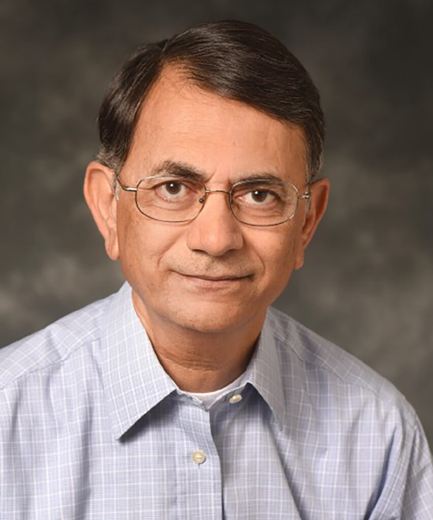 A man in glasses, Keerti Rathore. He is wearing a light colored plaid shirt. 