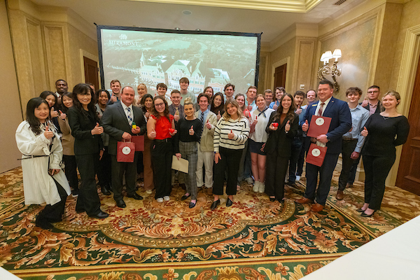 Group of students and teacher givng "thumbs up" in a meeting room at the Miramont Country Club.