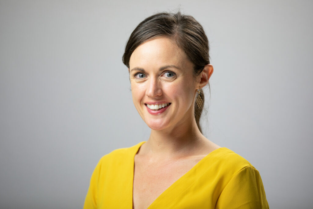 a smiling woman in a yellow shirt