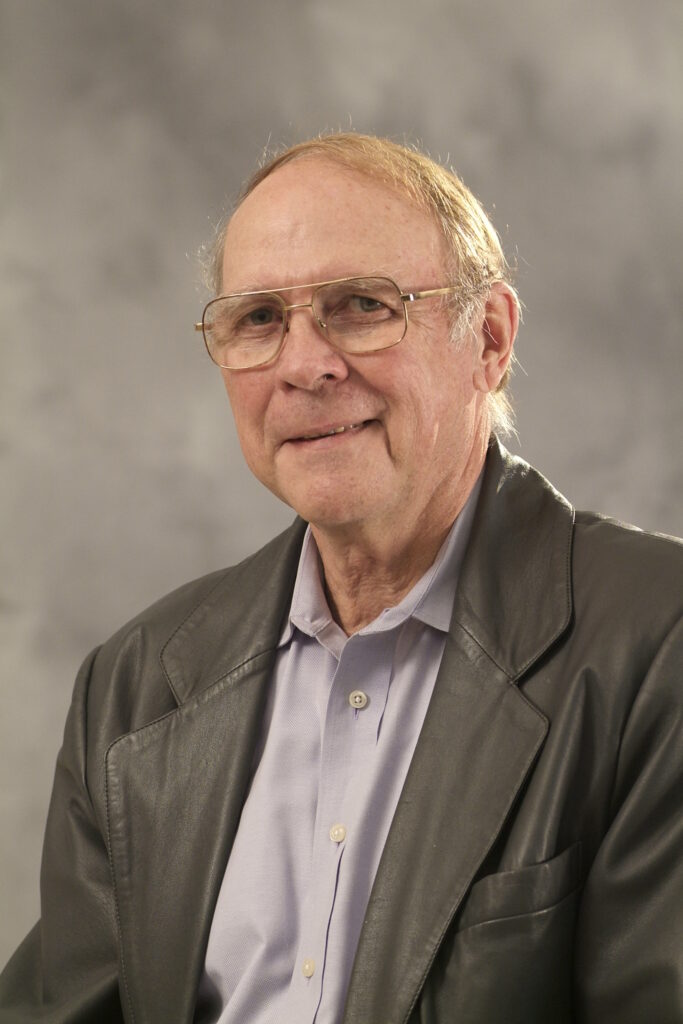 A man in a brown suit and light glasses, Ronald Randel, Ph.D., Texas A&M AgriLife Research Senior Faculty Fellow, Professor Emeritus