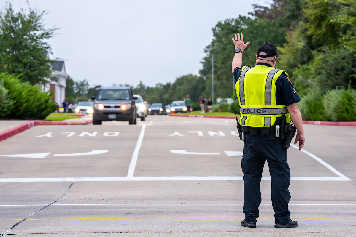 A police officer directing traffic in a school zone. 