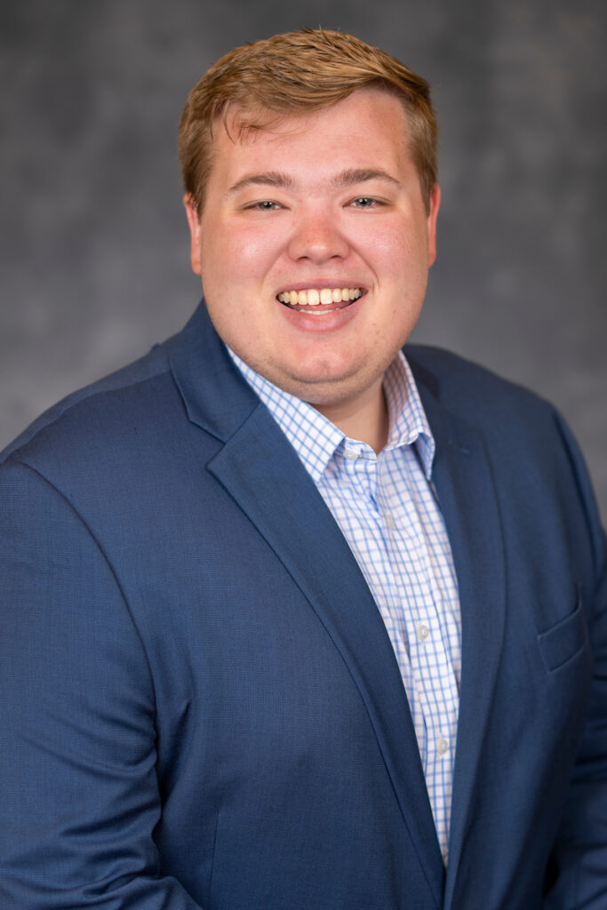 Smiling man, new ag agent, in a blue jacket and blue shirt