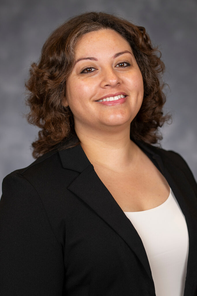 A smiling female agent in a black jacket with a white shirt